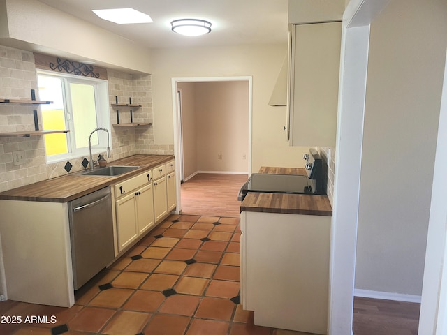 kitchen featuring white cabinetry, butcher block counters, sink, dishwasher, and dark tile patterned floors