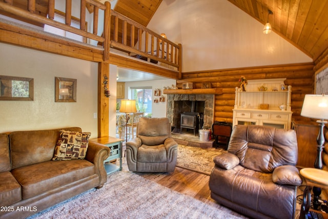 living room with log walls, high vaulted ceiling, wood ceiling, a wood stove, and wood finished floors