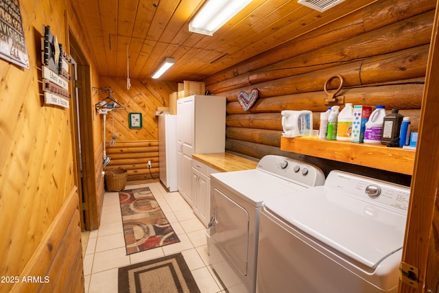 clothes washing area featuring wood ceiling, independent washer and dryer, rustic walls, light tile patterned floors, and cabinet space