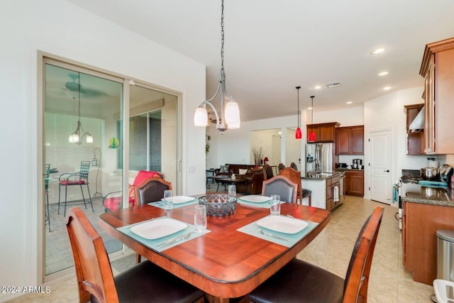 dining area featuring sink, a chandelier, and light tile patterned flooring