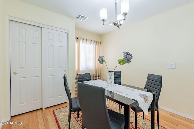 dining space featuring light hardwood / wood-style flooring and a chandelier