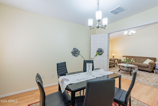 dining space with a notable chandelier and light hardwood / wood-style floors