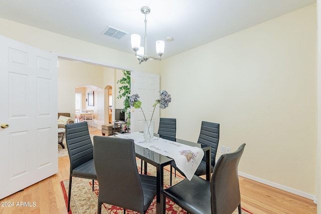 368 S 18th St, Coolidge, AZ 85128 - dining room featuring visible vents, baseboards, arched walkways, light wood-type flooring, and an inviting chandelier