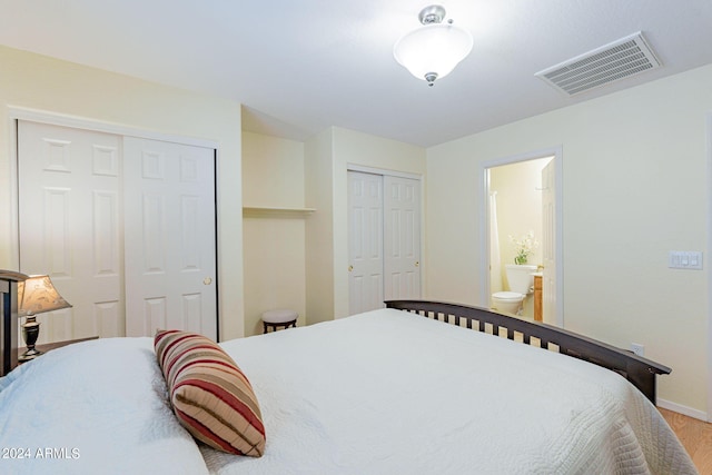 368 S 18th St, Coolidge, AZ 85128 - bedroom featuring two closets, baseboards, visible vents, ensuite bathroom, and wood finished floors