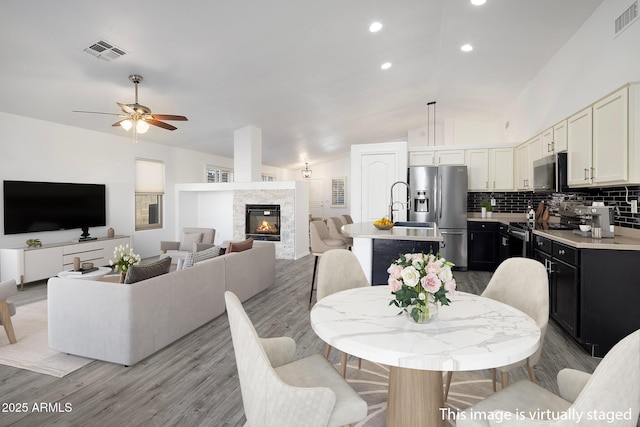 dining room featuring lofted ceiling, ceiling fan, and light hardwood / wood-style flooring