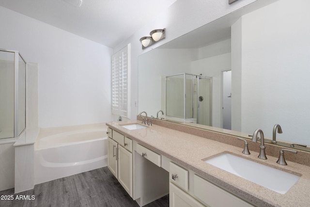 bathroom with wood-type flooring, vanity, and shower with separate bathtub