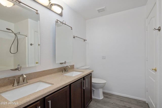 bathroom with toilet, a shower, wood-type flooring, and vanity