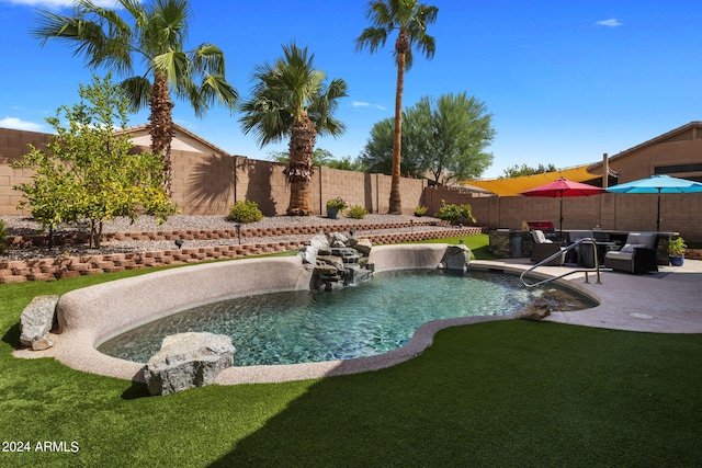 view of pool featuring a lawn, pool water feature, outdoor lounge area, and a patio