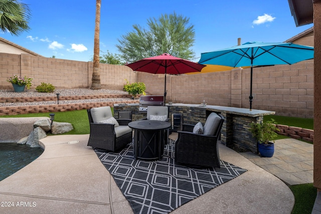 view of patio featuring exterior kitchen, an outdoor bar, and a grill