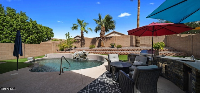 view of pool featuring an outdoor kitchen, a patio area, and a grill