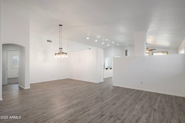 spare room with ceiling fan, a wealth of natural light, lofted ceiling, and hardwood / wood-style flooring