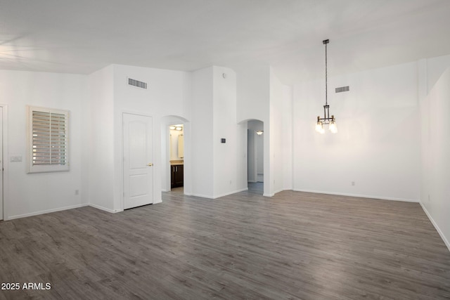 spare room featuring a high ceiling and dark hardwood / wood-style flooring