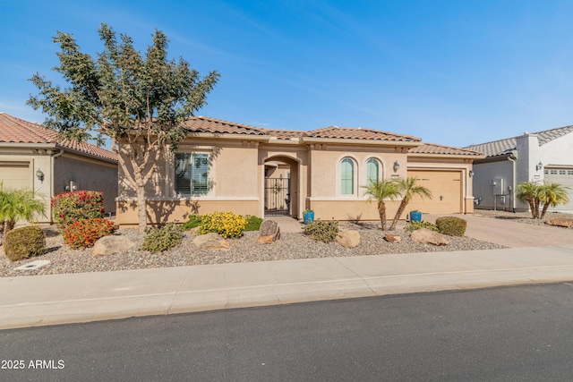 mediterranean / spanish house featuring a garage, driveway, a tiled roof, and stucco siding