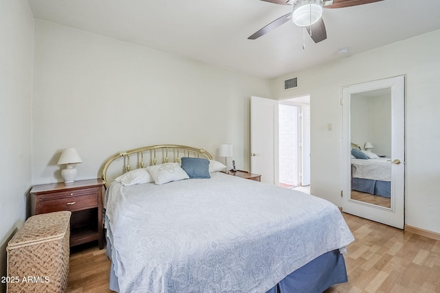 bedroom featuring light wood-style flooring, visible vents, and a ceiling fan