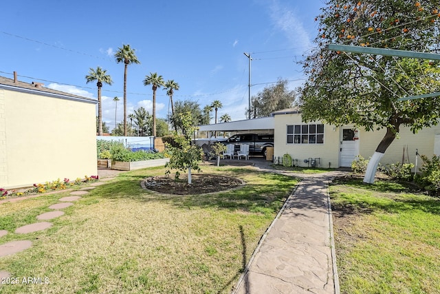 view of yard featuring an attached carport and fence