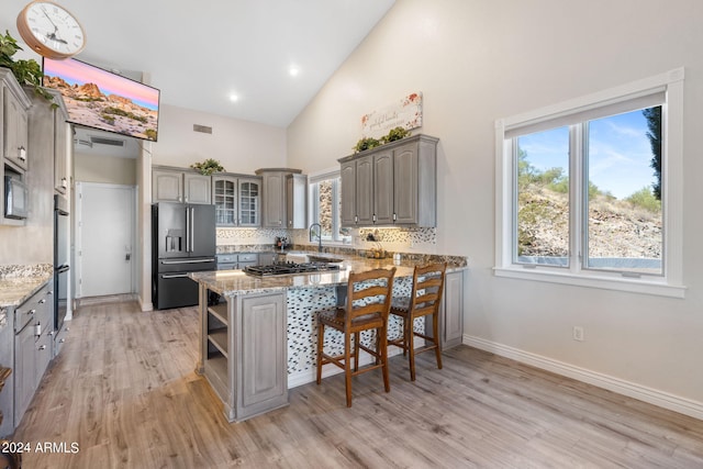 kitchen featuring stainless steel appliances, kitchen peninsula, and light hardwood / wood-style flooring