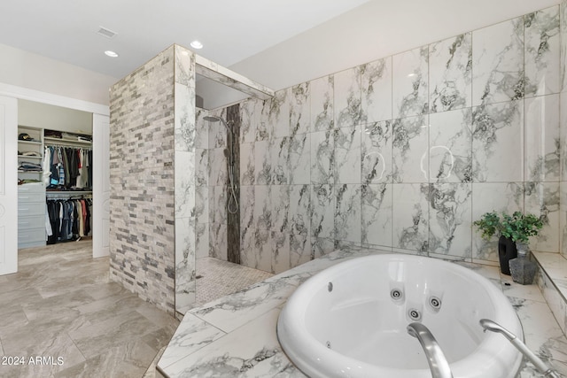 bathroom featuring plus walk in shower and tile walls