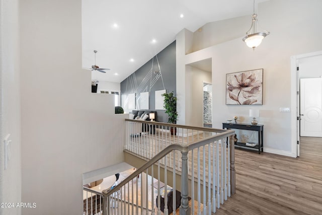 stairs featuring high vaulted ceiling, wood-type flooring, and ceiling fan