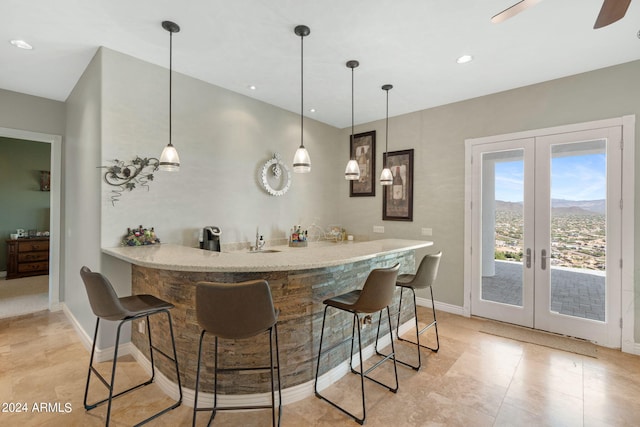 bar with ceiling fan, hanging light fixtures, and french doors