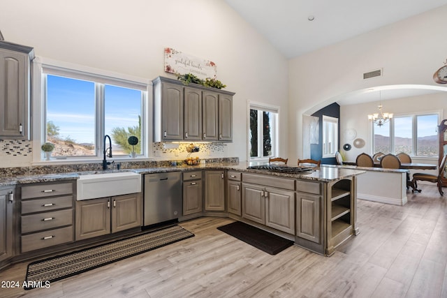 kitchen featuring sink, tasteful backsplash, light hardwood / wood-style flooring, a chandelier, and stainless steel appliances