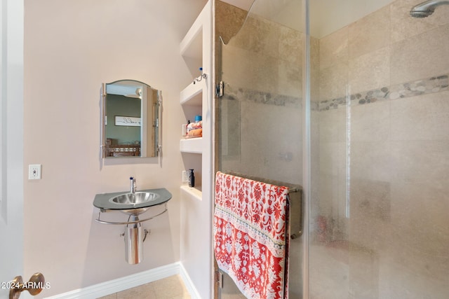 bathroom with tile patterned flooring, an enclosed shower, and sink