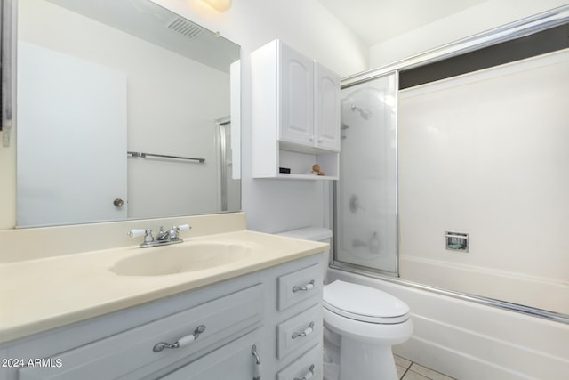 full bathroom featuring tile patterned floors, vanity, toilet, and shower / bath combination with glass door