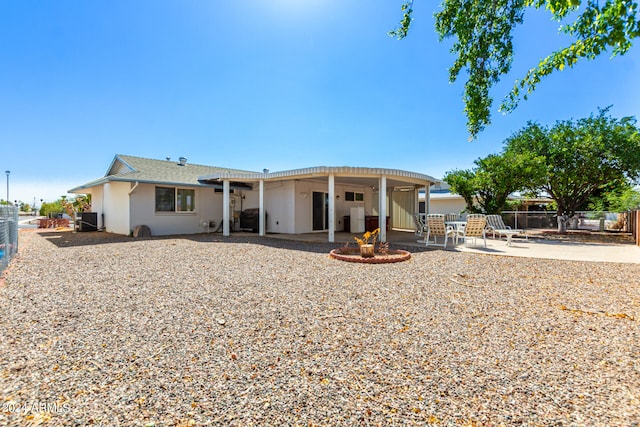 back of property with central AC unit, an outdoor fire pit, and a patio area