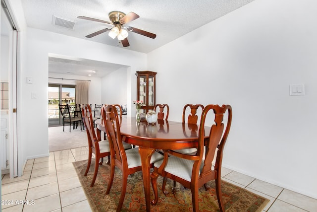 tiled dining area featuring ceiling fan and a textured ceiling