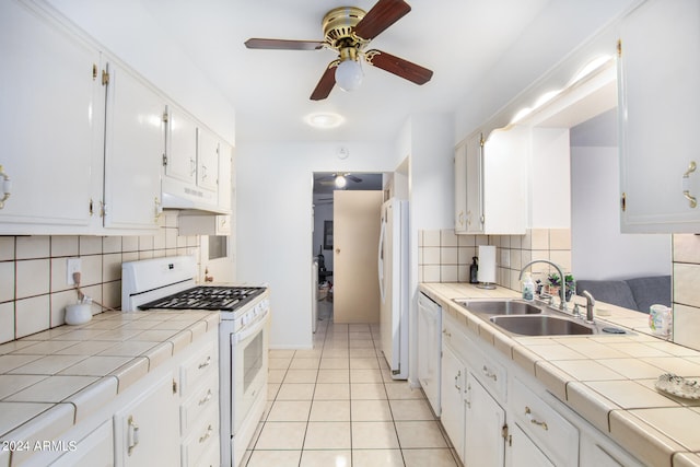 kitchen featuring white appliances, sink, tile counters, light tile patterned flooring, and white cabinetry