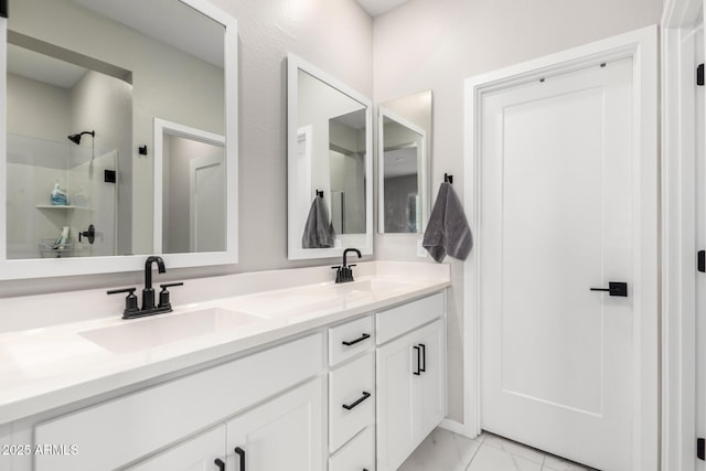 bathroom featuring double vanity, marble finish floor, and a sink