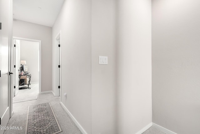 hall featuring light carpet and baseboards