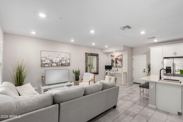 living area with light tile patterned flooring, visible vents, and recessed lighting