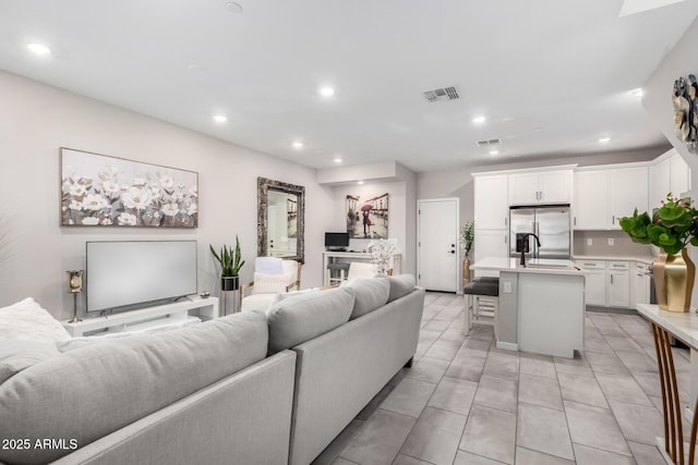 living room featuring light tile patterned floors, visible vents, and recessed lighting