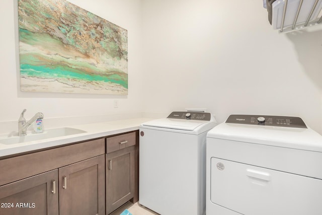 laundry room with cabinets, separate washer and dryer, and sink