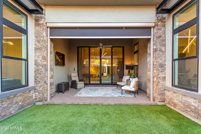 entrance to property featuring a lawn and a patio area