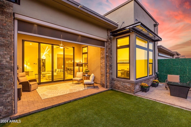 back house at dusk featuring a patio area