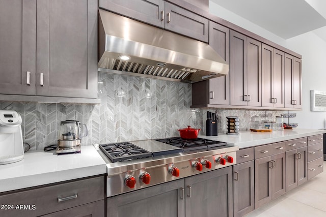 kitchen with tasteful backsplash, light tile patterned flooring, and stainless steel gas stovetop