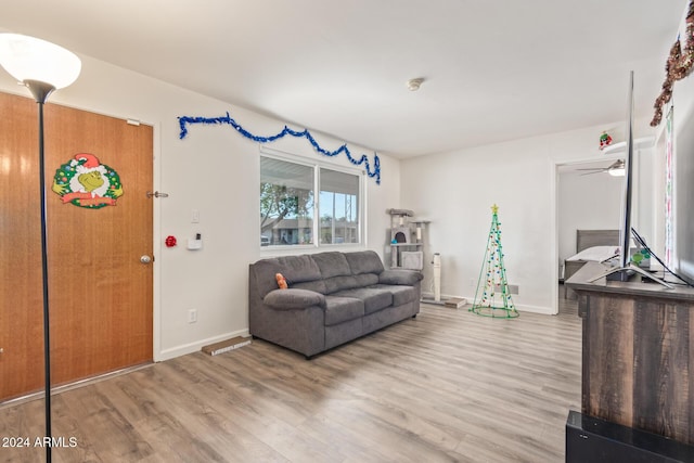 living room featuring hardwood / wood-style floors and ceiling fan