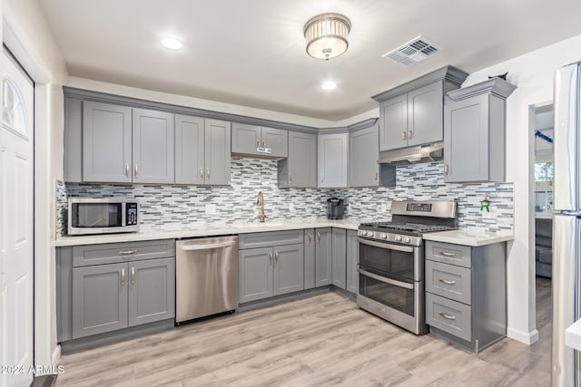 kitchen with gray cabinets, sink, appliances with stainless steel finishes, and light hardwood / wood-style flooring