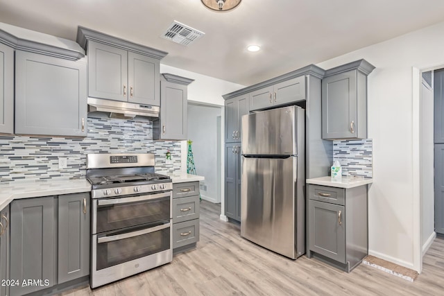 kitchen featuring gray cabinets, stainless steel appliances, and light hardwood / wood-style floors