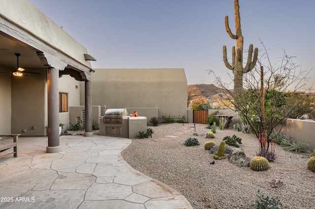 view of yard featuring a gate, fence, area for grilling, ceiling fan, and a patio area