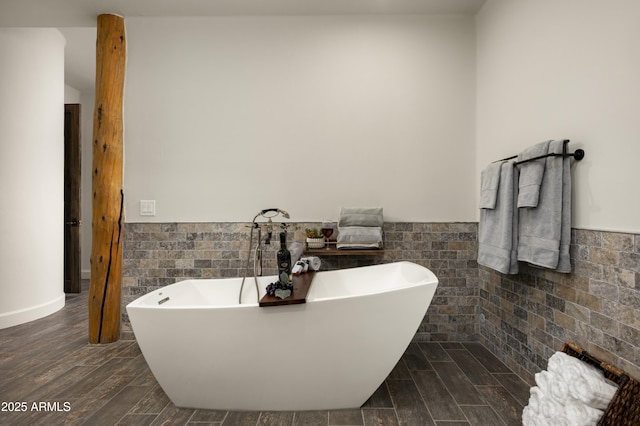 bathroom with a soaking tub, tile walls, and wainscoting