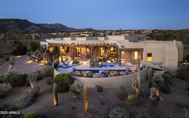 back of house with an outdoor pool, a mountain view, and a patio