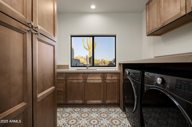 washroom featuring washer and clothes dryer, recessed lighting, cabinet space, and a sink