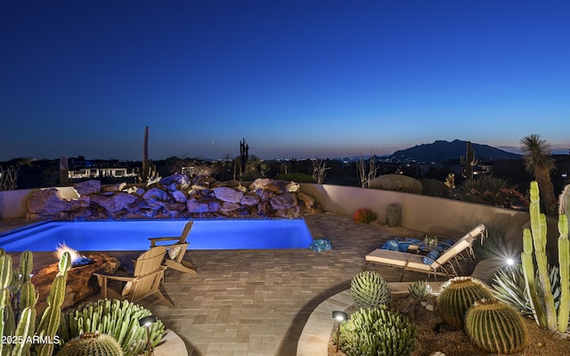 outdoor pool featuring a mountain view and a patio