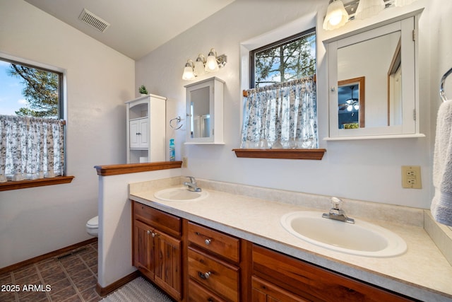 full bath featuring a sink, visible vents, toilet, and double vanity