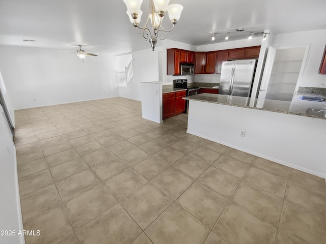 kitchen with appliances with stainless steel finishes, decorative light fixtures, light tile patterned flooring, light stone countertops, and ceiling fan with notable chandelier