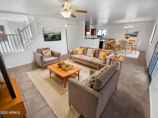 living room featuring tile patterned floors and ceiling fan with notable chandelier