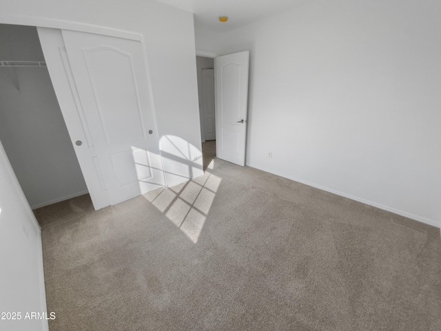 unfurnished bedroom featuring a closet and light carpet