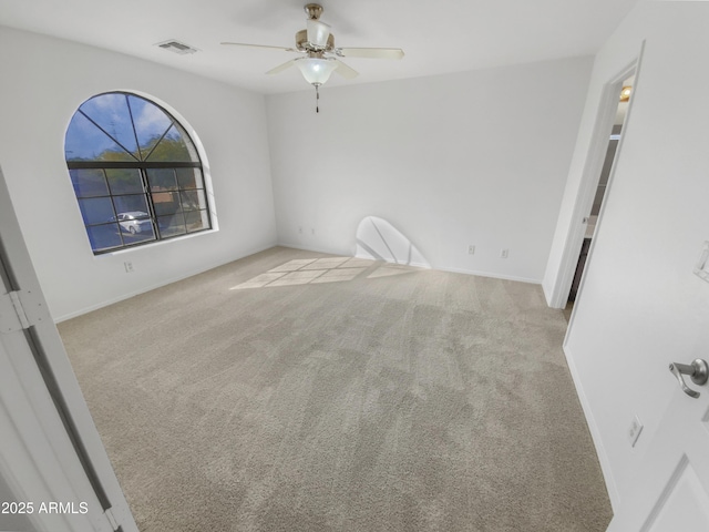 empty room featuring ceiling fan and light colored carpet